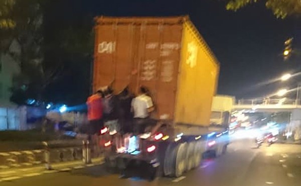 Rợn người cảnh 4 thanh niên đu mình sau container đang chạy