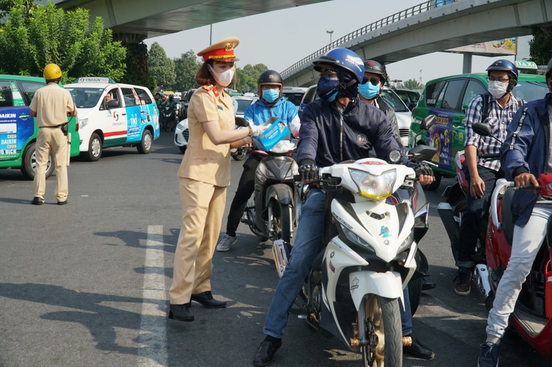 Nu CSGT TP HCM doi nang phat khau trang cho nguoi dan