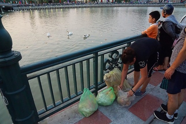 Nguoi phu nu than nhien vut banh cho thien nga an khien nhieu nguoi lac dau